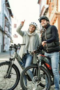 Henkilöt pyöräilemässä kaupungissa